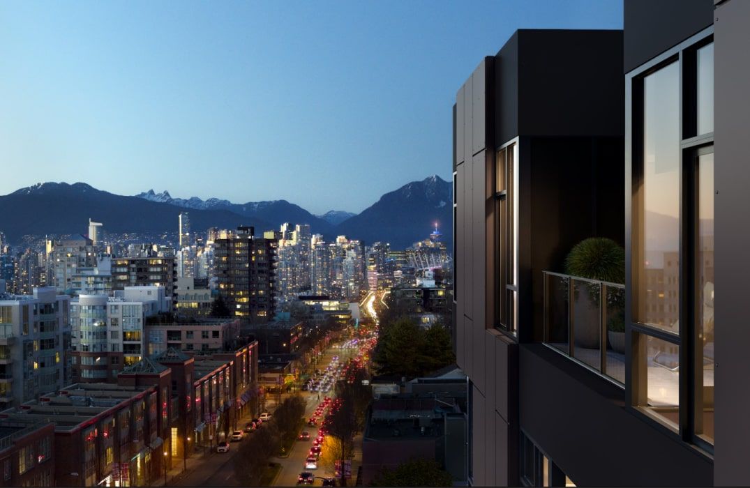 a view of a city at night with mountains in the background