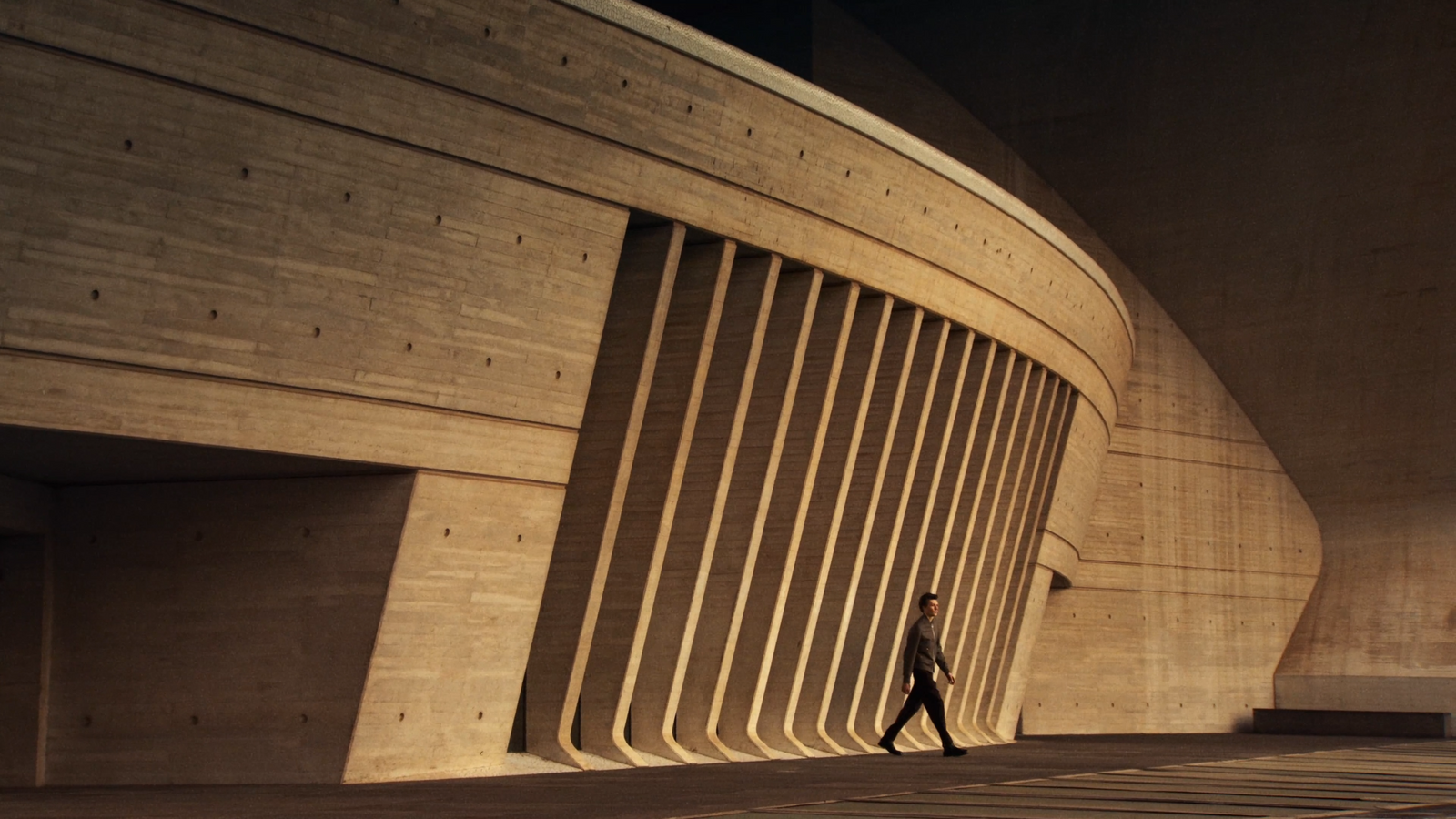 a man walking down a sidewalk next to a building