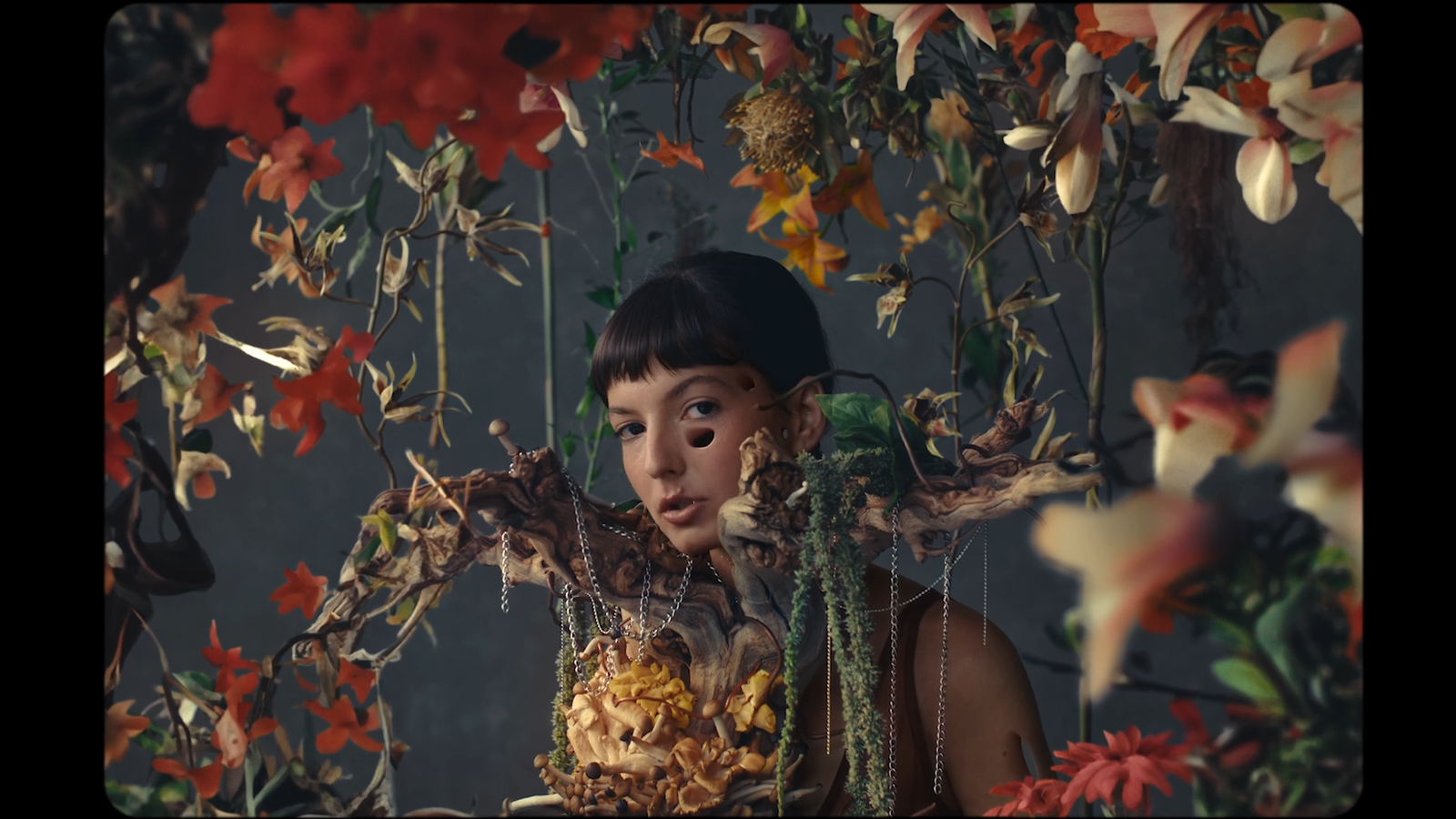 a woman standing in front of a bunch of flowers