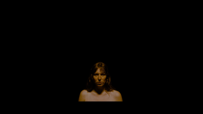 a woman with long hair standing in the dark