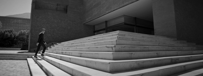 a man in a suit walking up some steps