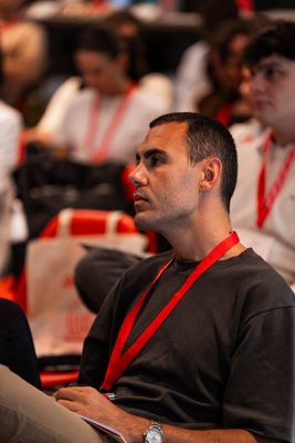 a man in a black shirt and a red lanyard around his neck