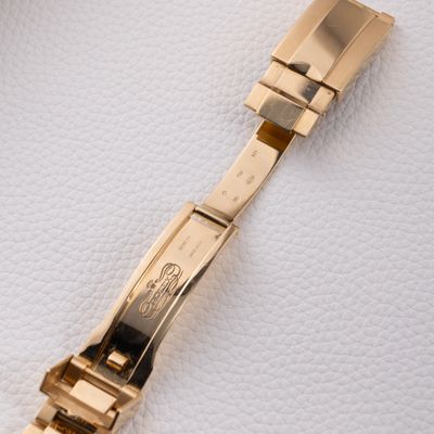 a close up of a watch on a white surface