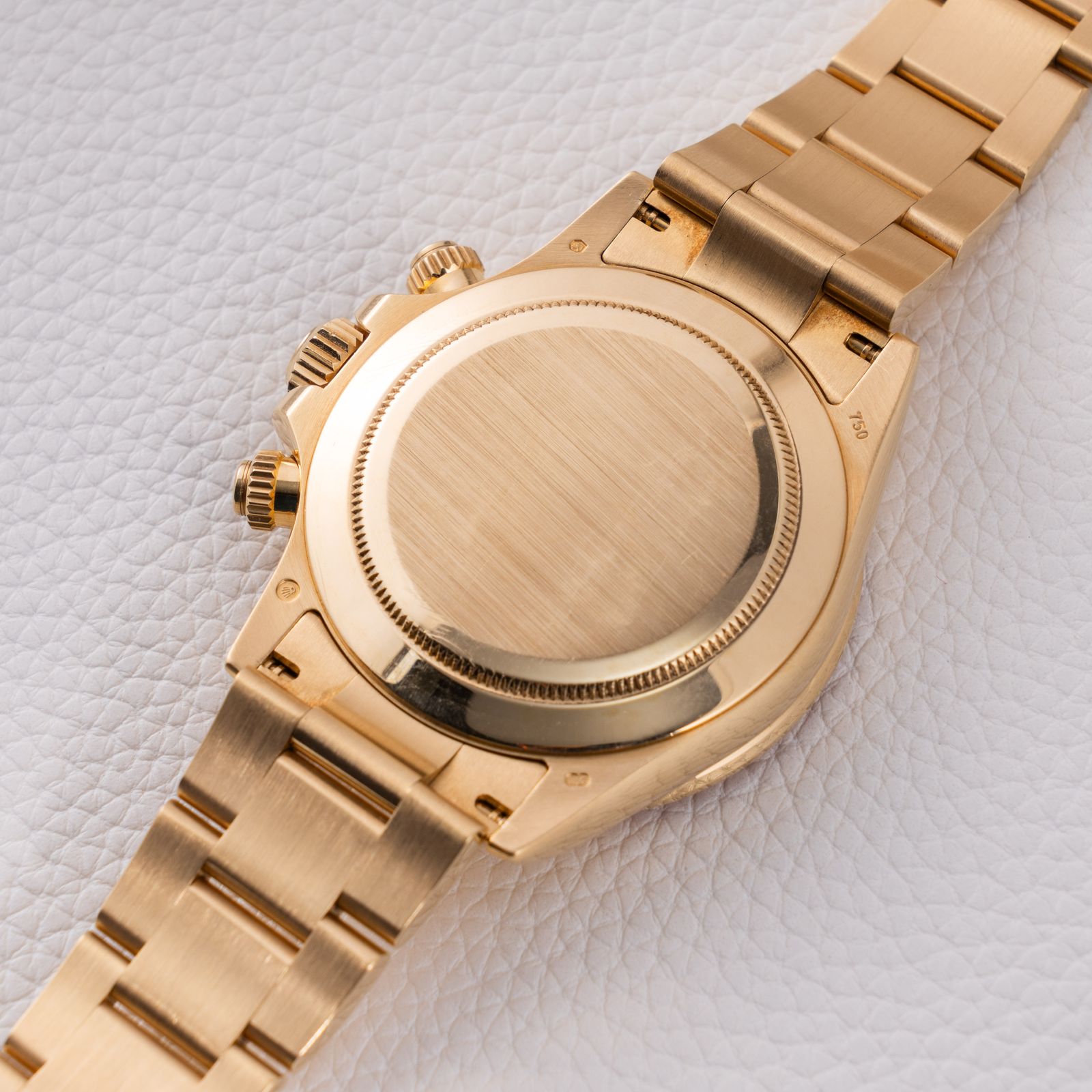 a gold watch sitting on top of a white surface
