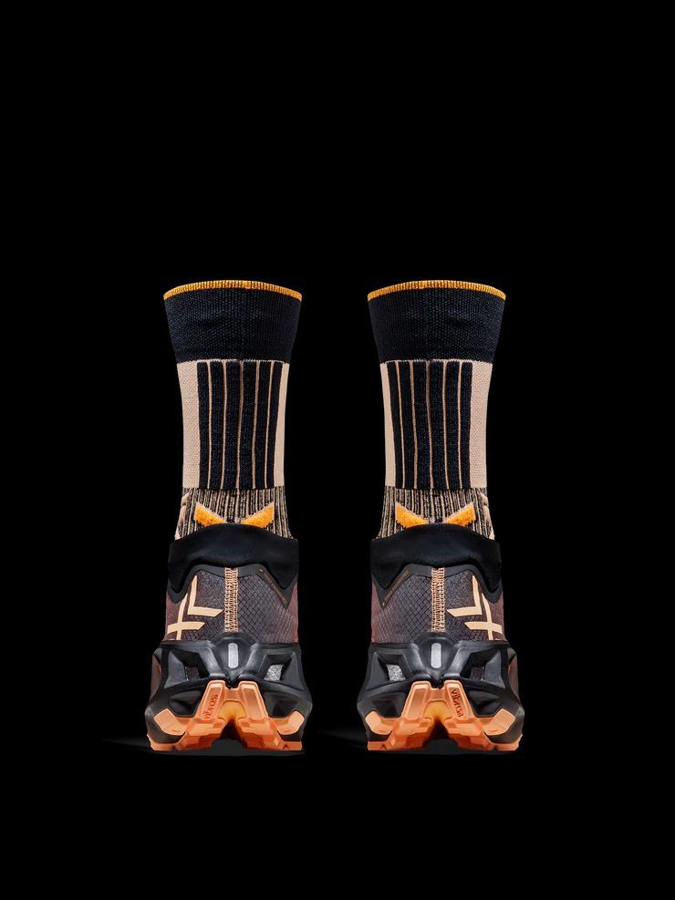 a pair of black and orange socks on a black background