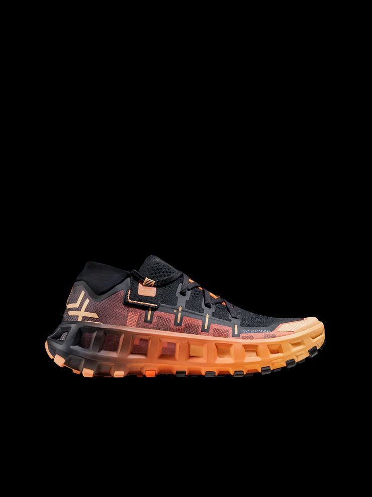 a pair of black and orange sneakers on a black background