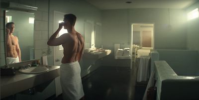 a man standing in front of a bathroom mirror