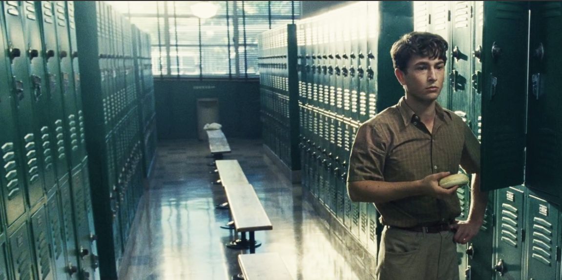 a man standing in a locker holding a frisbee