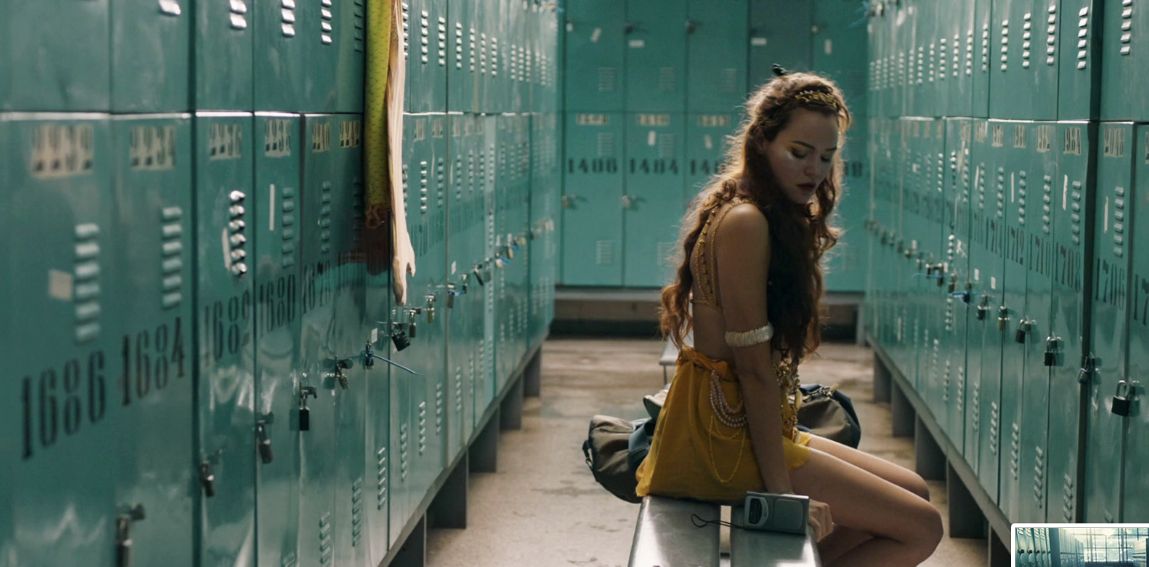 a woman sitting on a bench in a locker