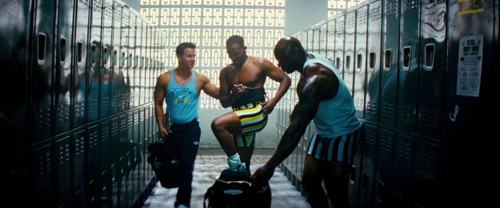 a group of young men standing in a hallway next to lockers