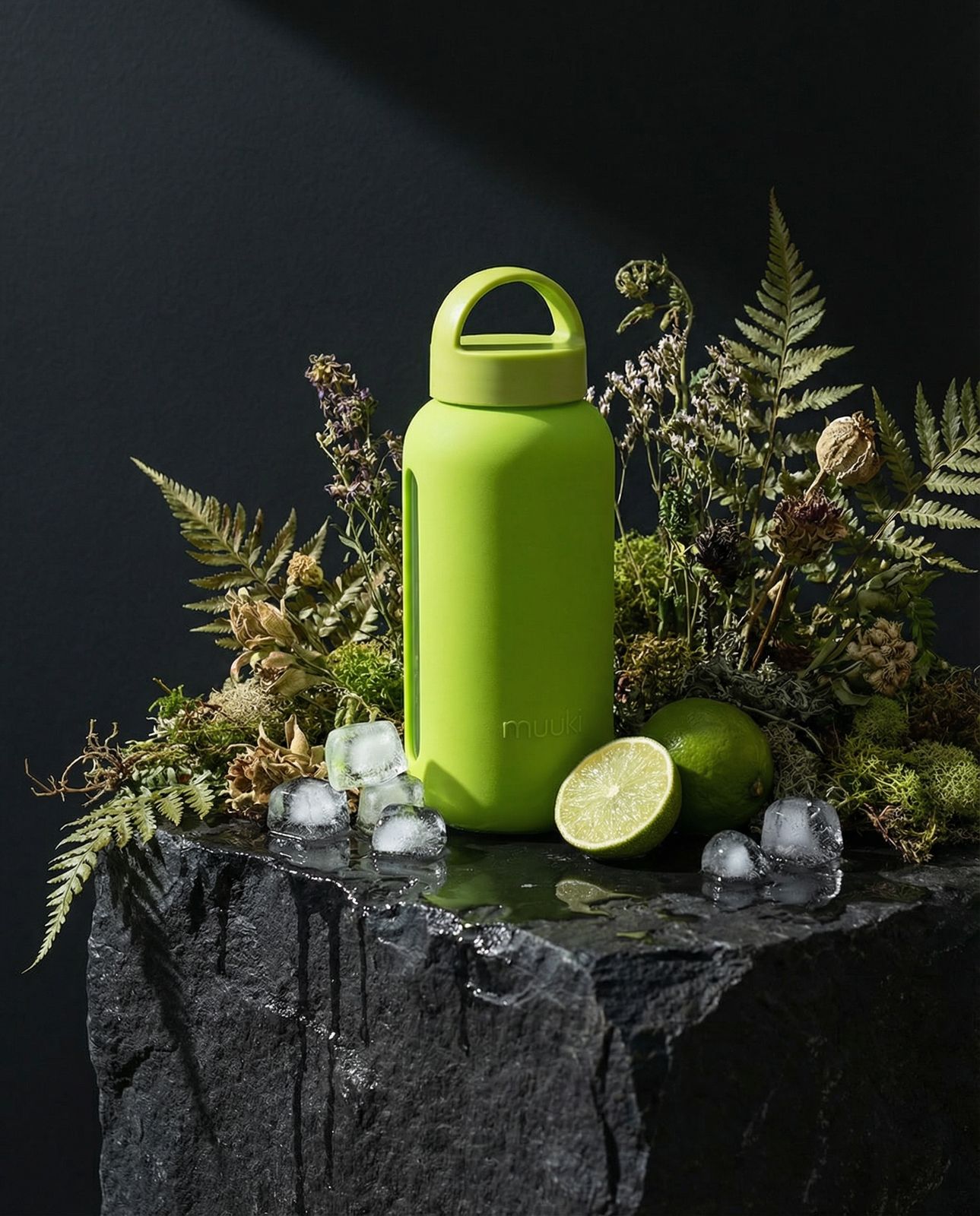 a green water bottle sitting on top of a rock