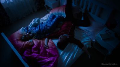 a person laying on a bed in a dark room