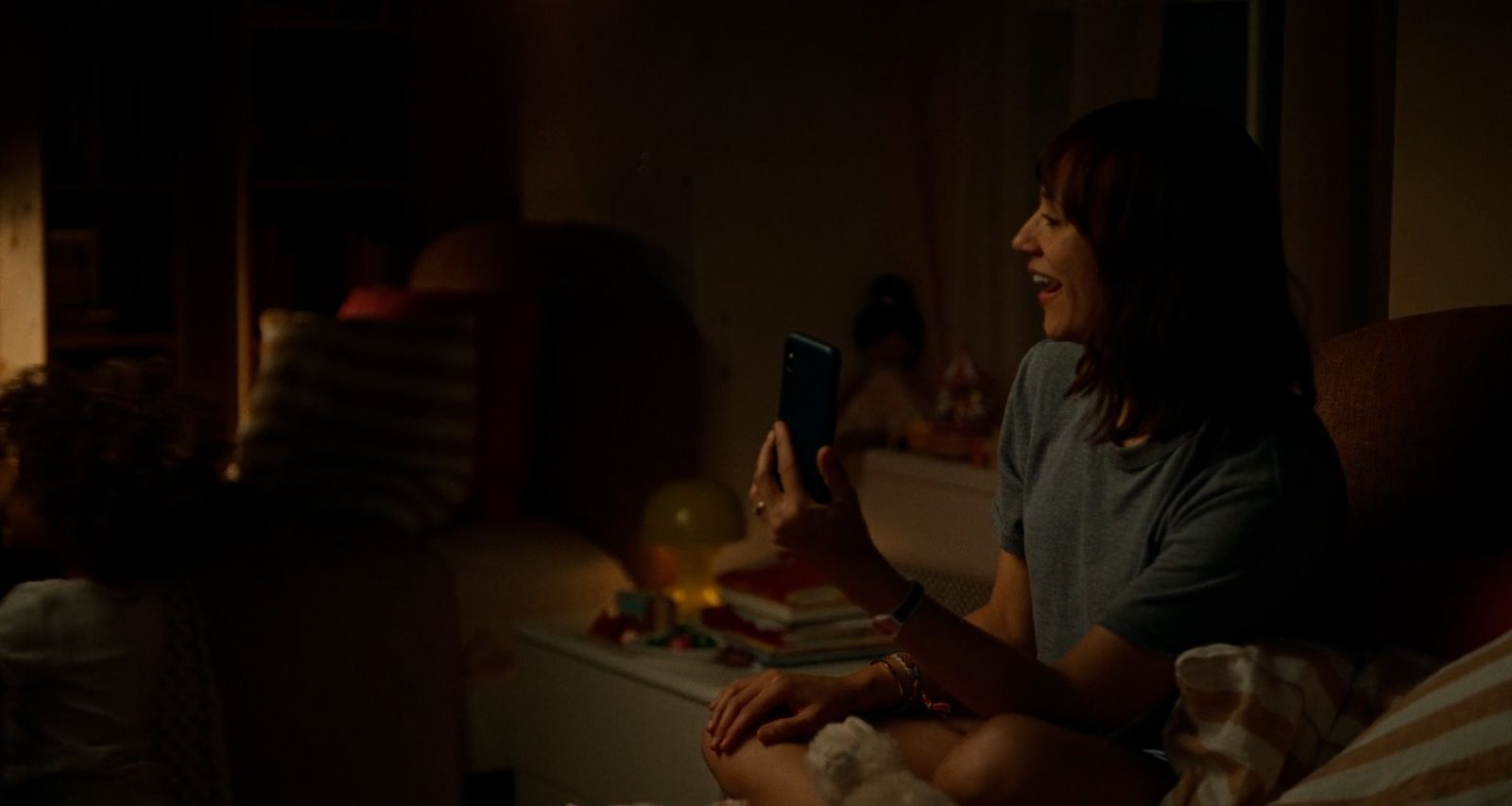 a woman sitting on a couch holding a cell phone