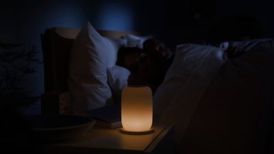 a person sleeping in a bed with a night light on