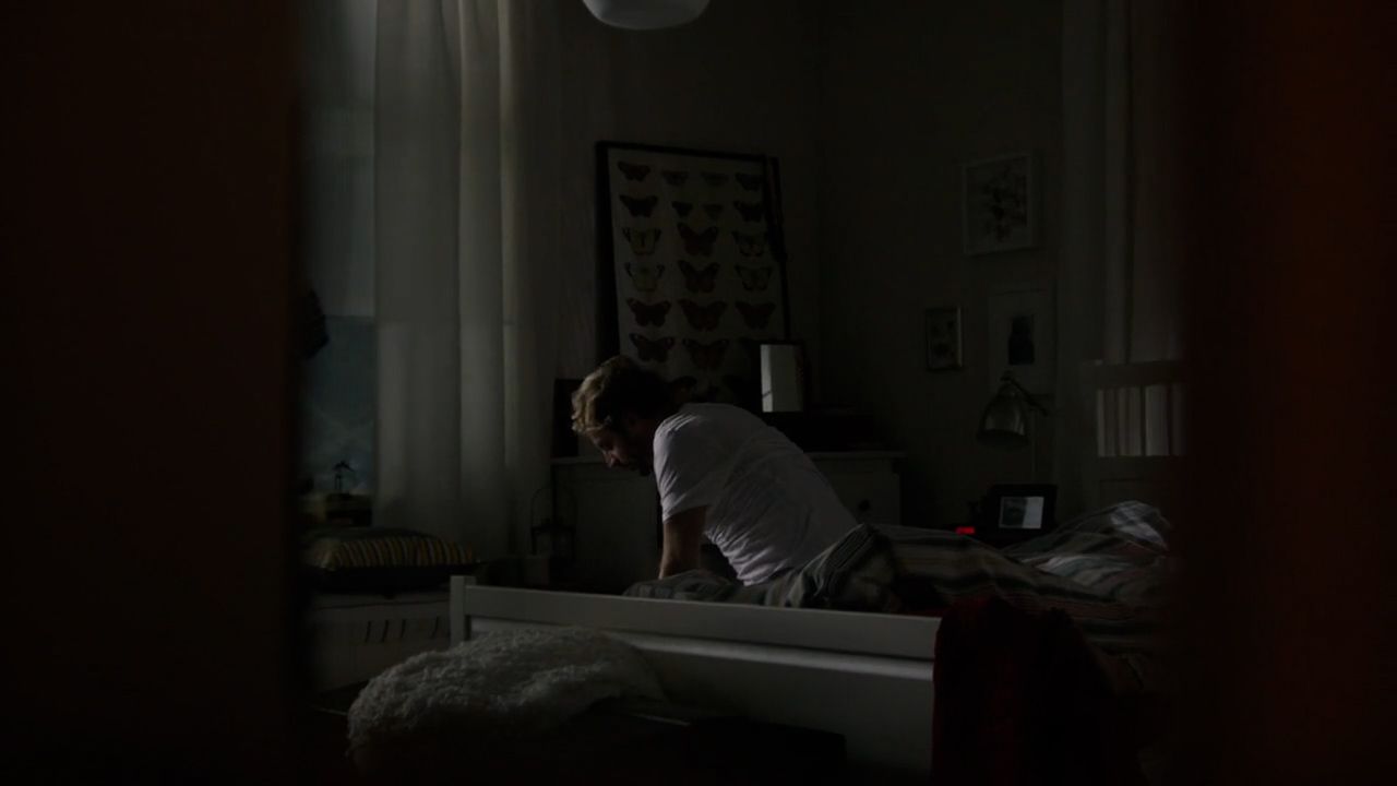 a person sitting on a bed in a dark room