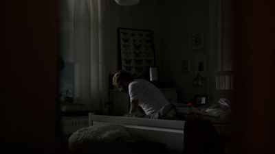 a person sitting on a bed in a dark room