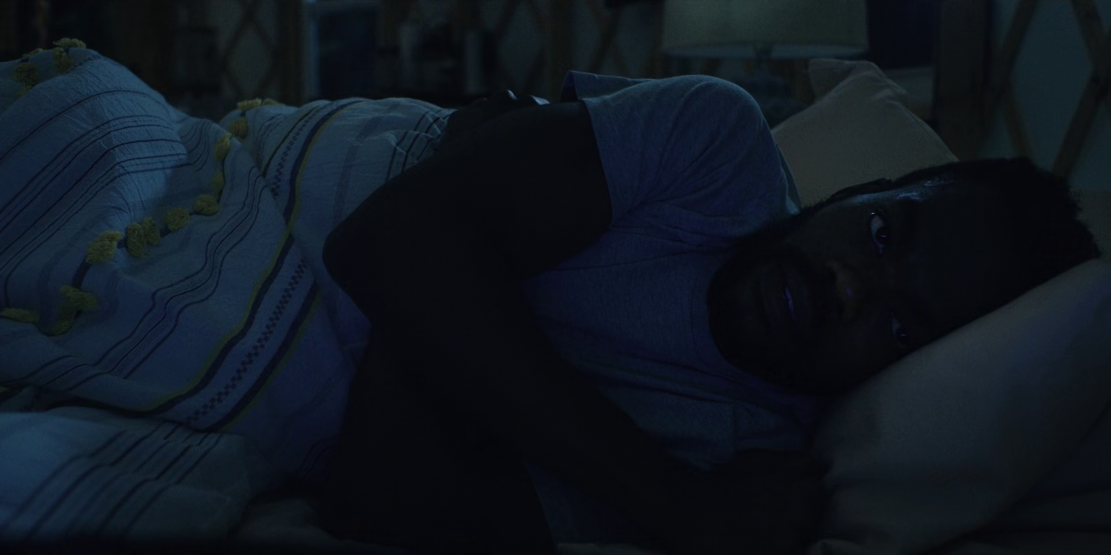 a man laying on a bed in a dark room