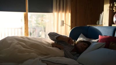 a little girl laying in a bed under a blanket