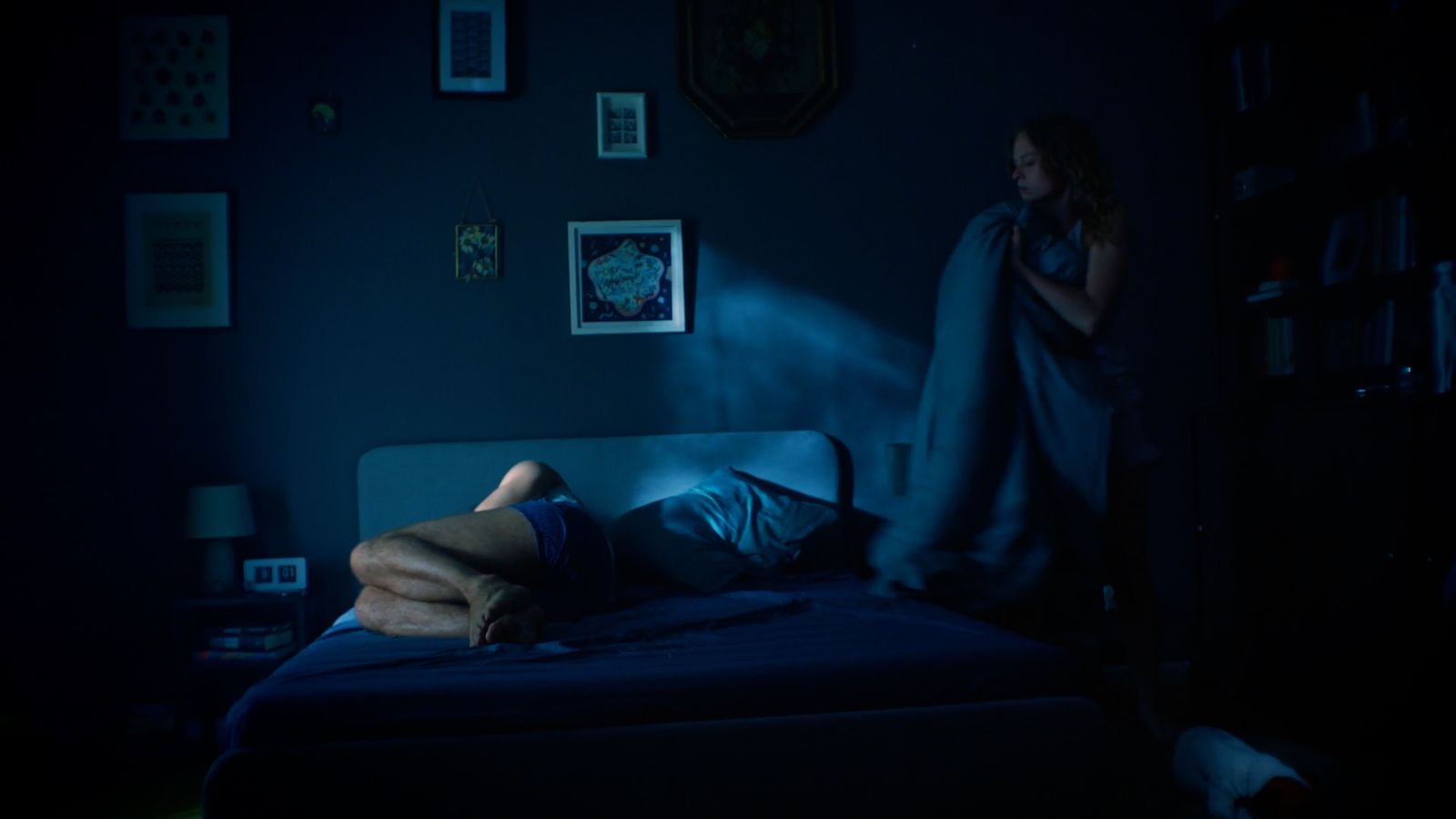 a person laying on a bed in a dark room