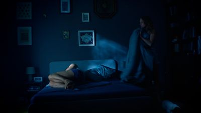 a person laying on a bed in a dark room