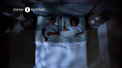 a man and woman laying in a bed under a blanket
