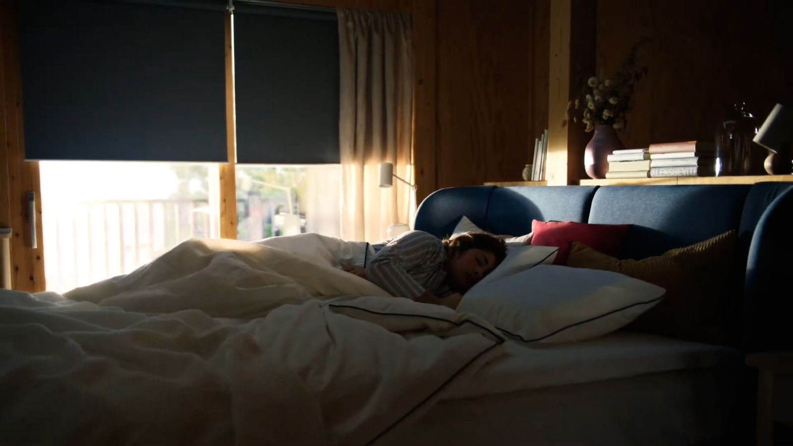 a person laying in a bed with pillows