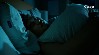 a man sleeping in a bed in the dark