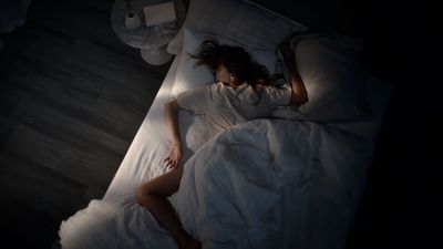 a woman laying in a bed in the dark