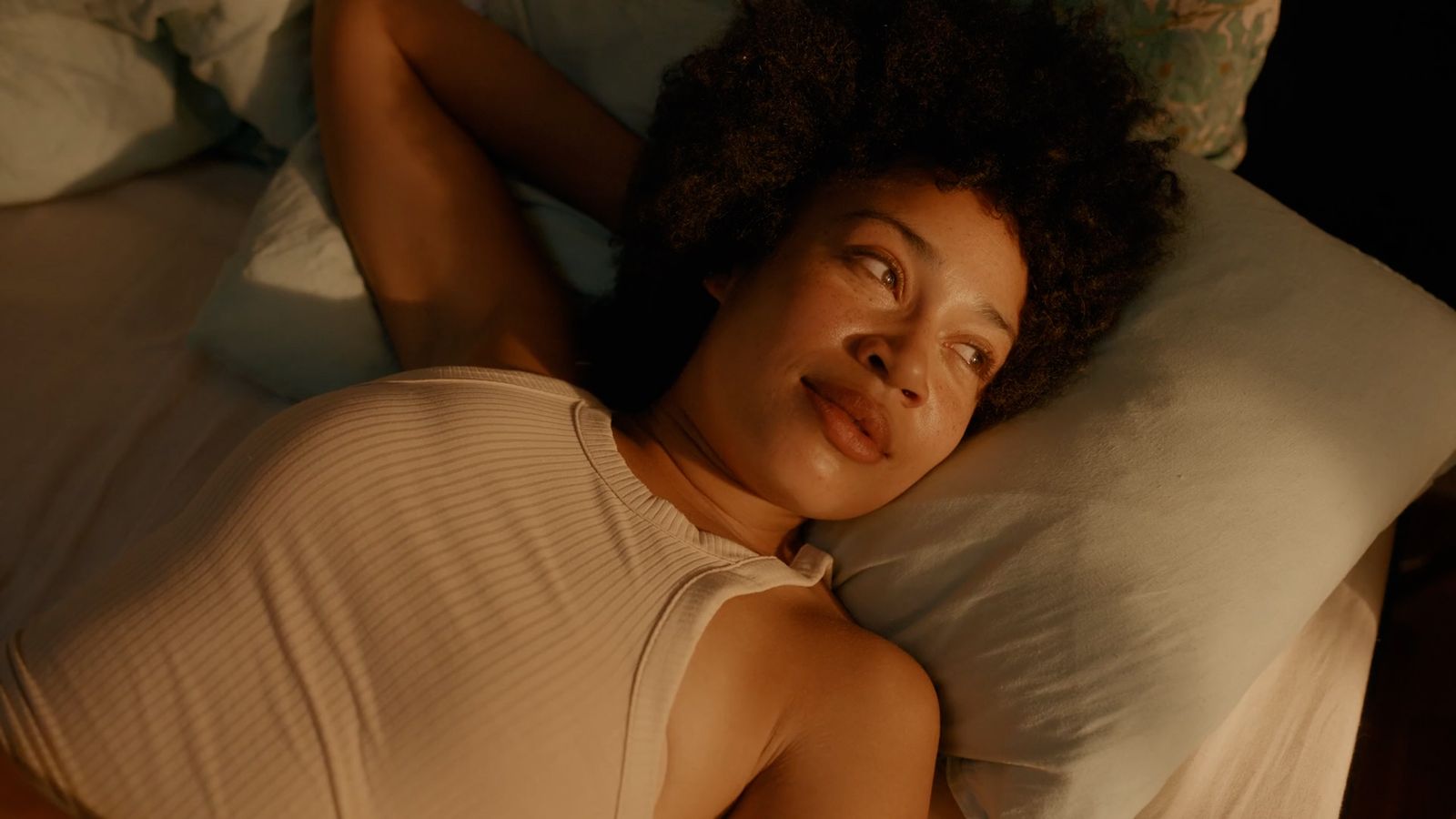 a woman laying in bed with her eyes closed