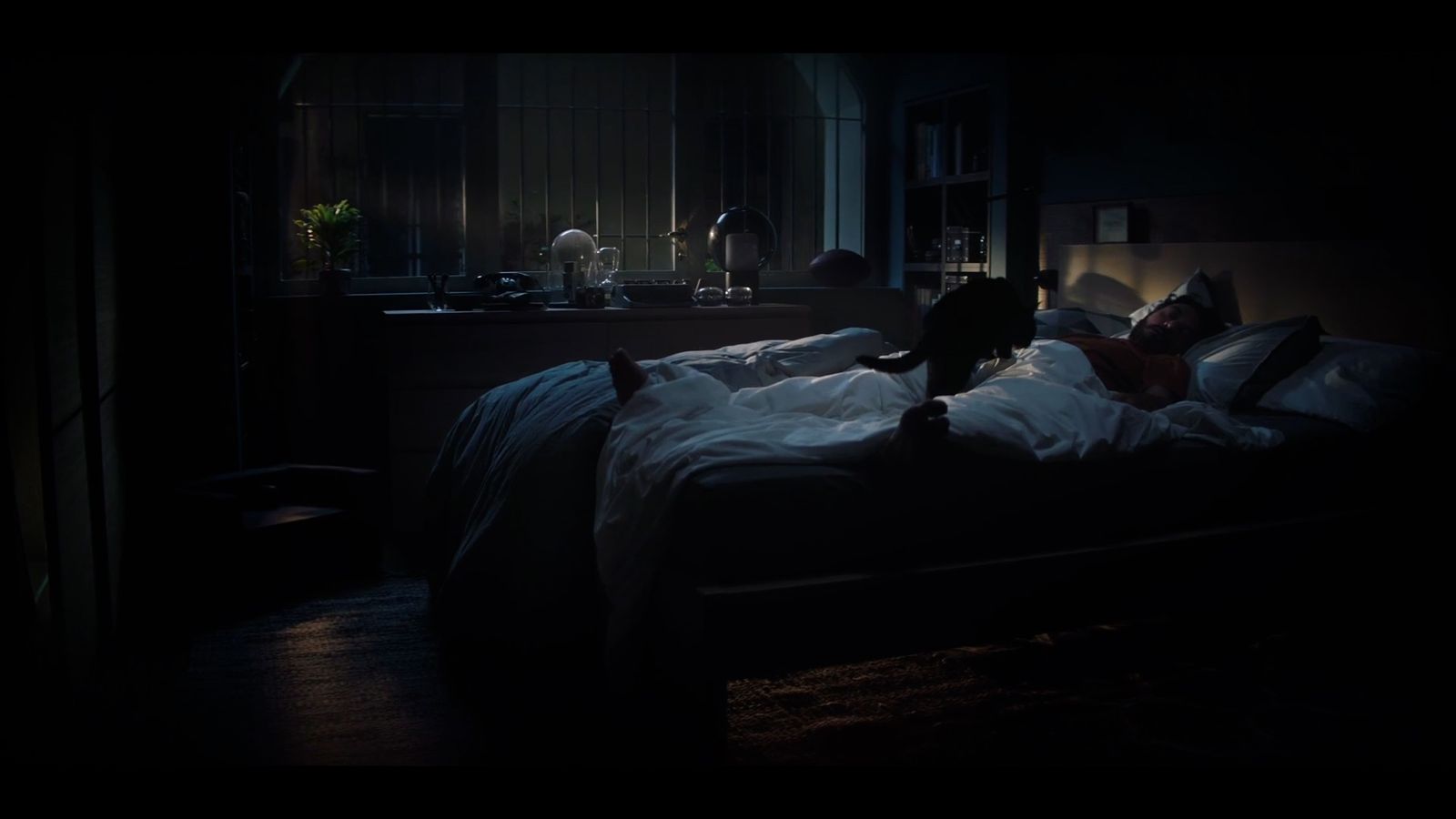 a person laying in a bed in a dark room