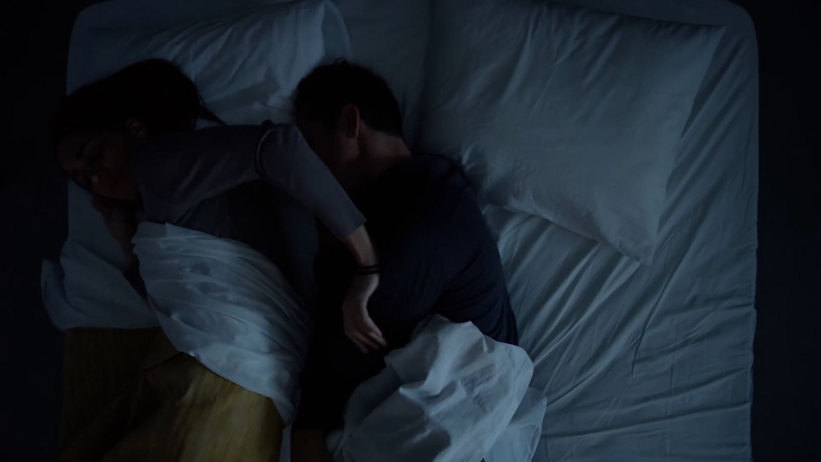 a man and a woman sleeping in a bed