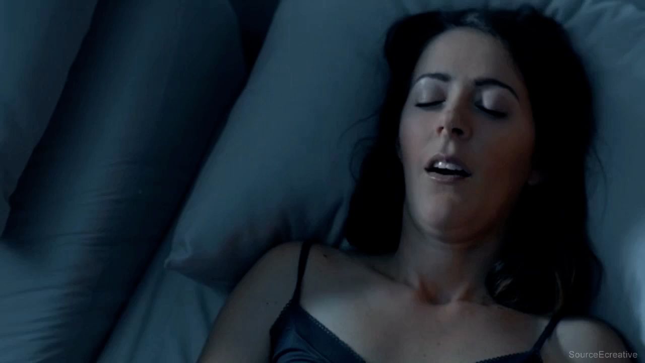 a woman laying in bed with her eyes closed