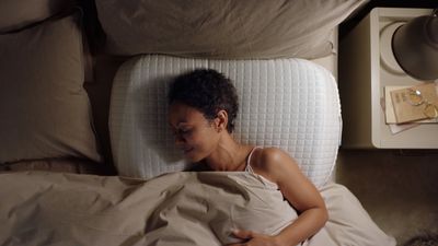 a woman laying in a bed with a pillow