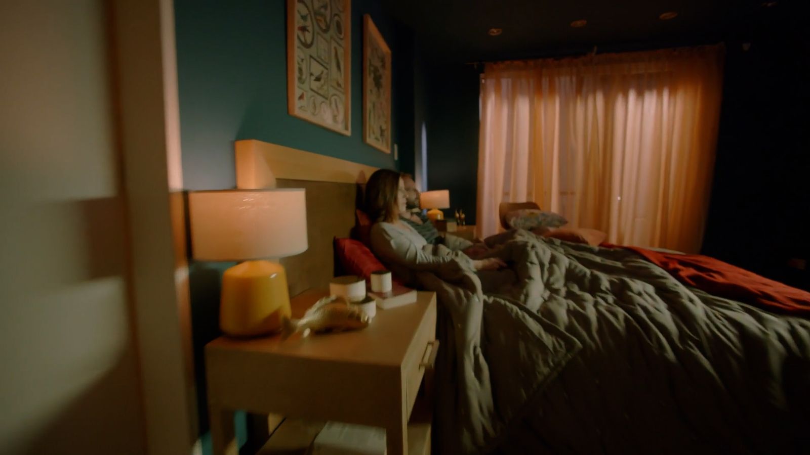 a woman sitting on a bed in a dark room