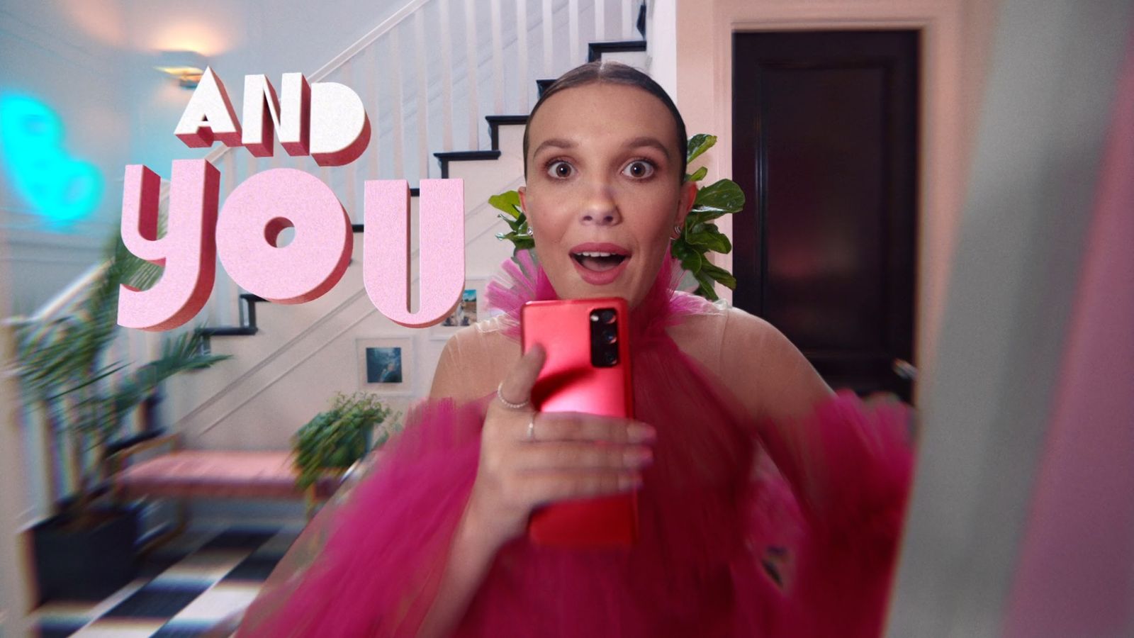 a woman in a pink dress holding a cell phone