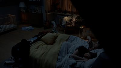 a person laying in a bed in a dark room