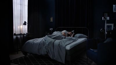 a person laying in a bed in a dark room