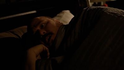 a man laying on top of a bed in a dark room