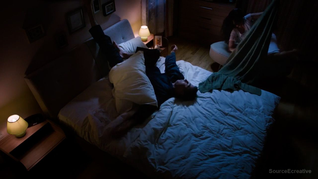 a person laying on a bed in a dark room