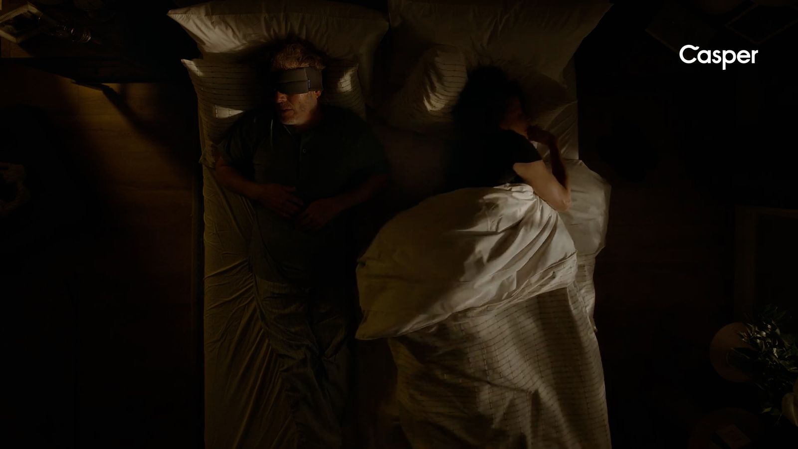 a man and a woman sleeping in a dark room