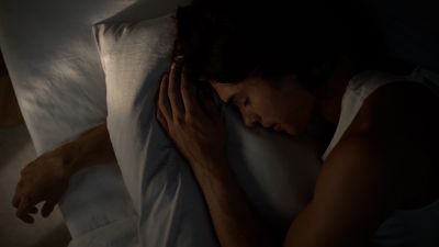 a woman laying in bed with her head on the pillow