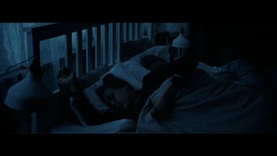 a person sleeping in a crib in a dark room