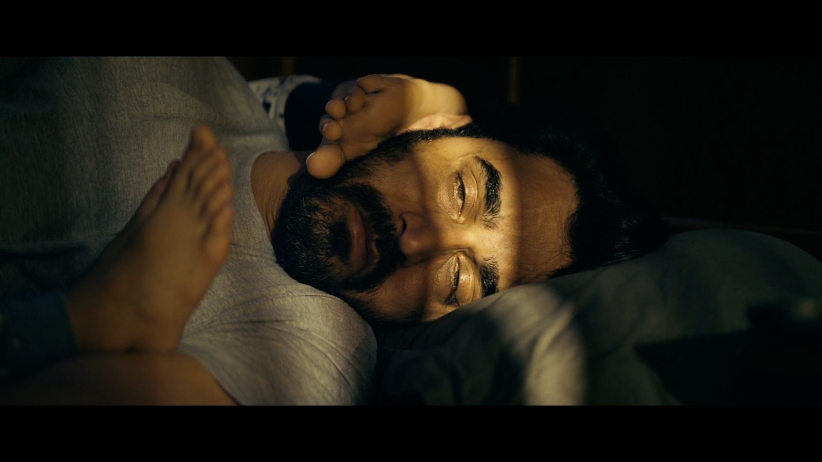 a man laying on top of a bed next to a woman