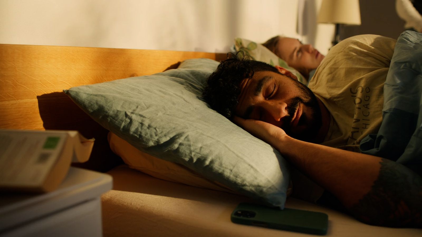 a man and a woman sleeping on a bed