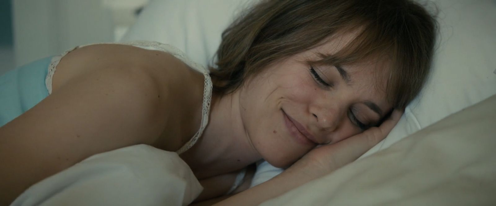 a woman laying in bed with her eyes closed