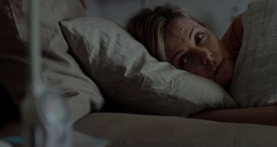 a woman laying in bed with her eyes closed