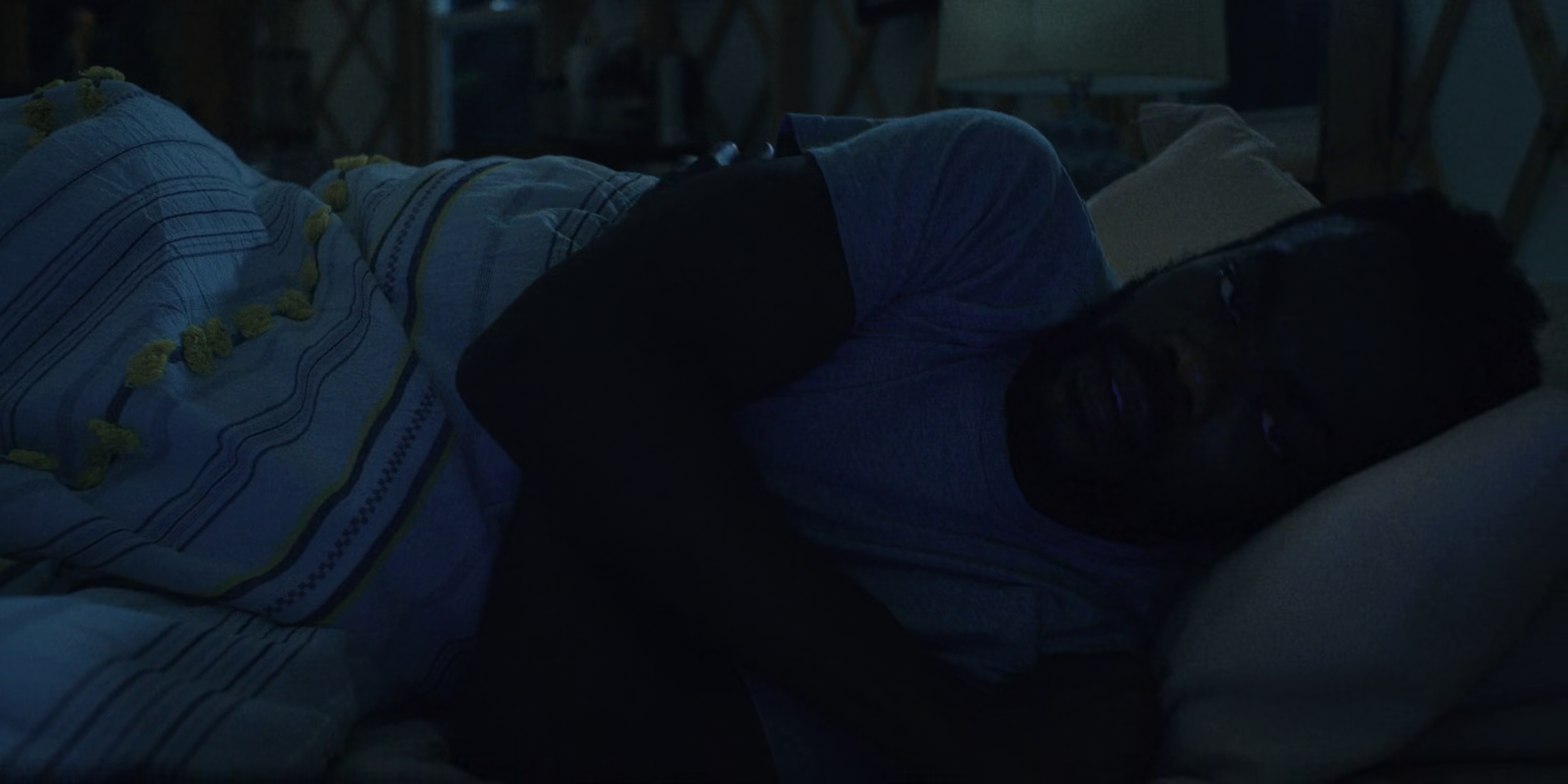 a man sleeping on a bed in a dark room