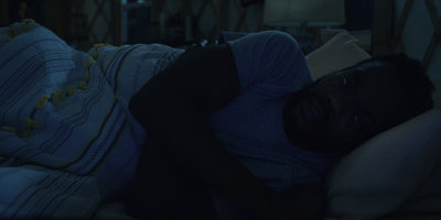 a man sleeping on a bed in a dark room