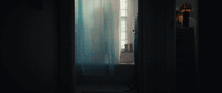 a dark room with a window and a curtain