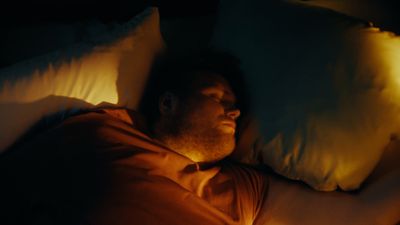 a man laying in bed with his eyes closed